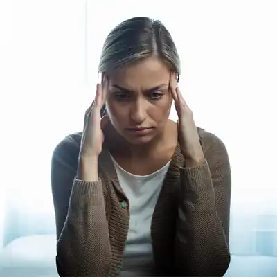  Woman with fingers to her temples.