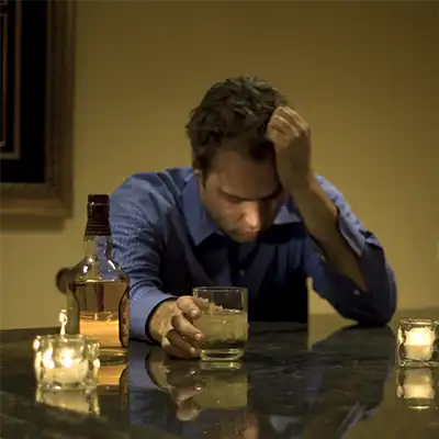  A man drinking alone needing alcohol rehab.